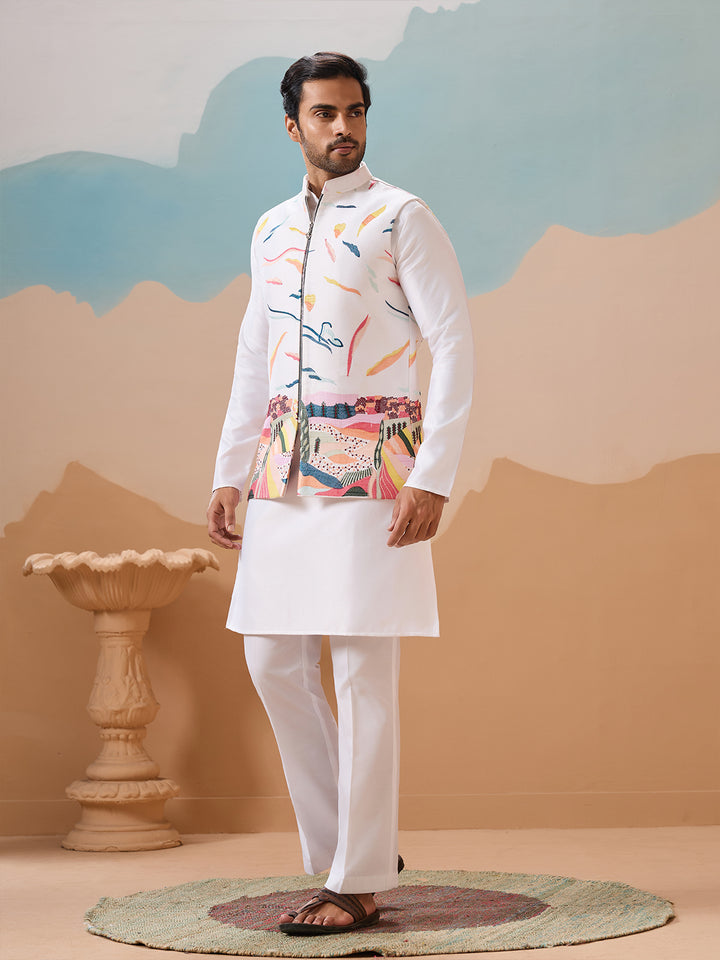 Man wearing a traditional outfit with a colorful jacket and white pants against a painted wall.