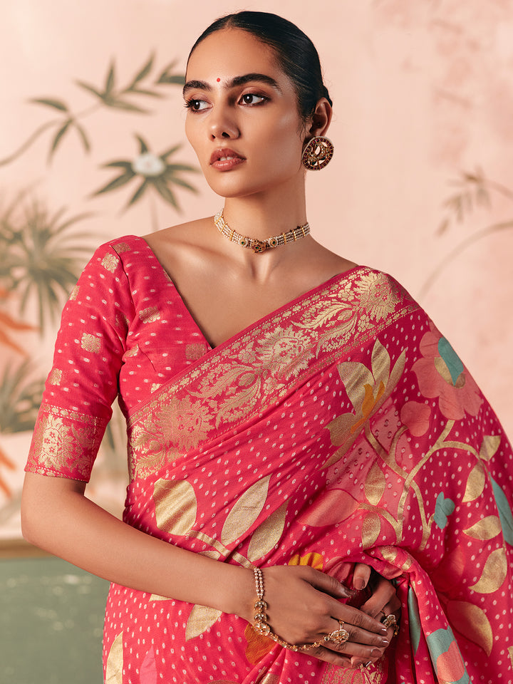 Woman wearing a pink saree with floral patterns against a light pink background