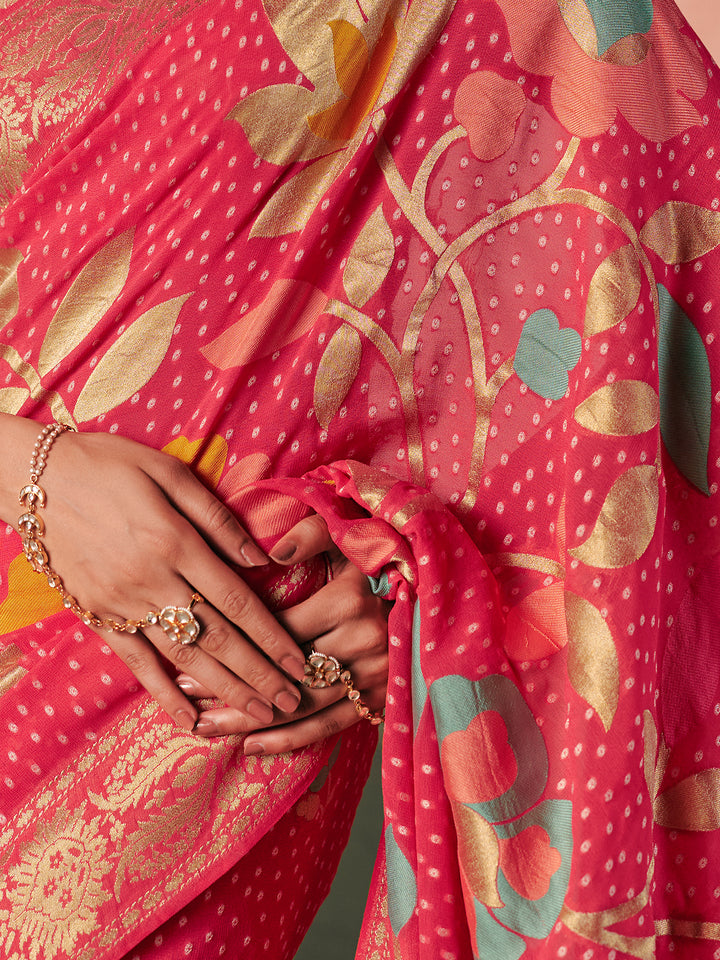 Close-up of a person wearing a red saree with gold and green patterns, holding the fabric.