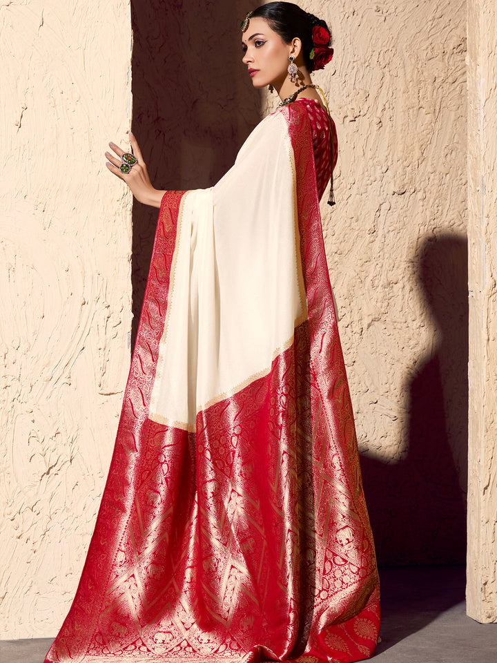 Woman wearing a red and white saree against a textured wall.