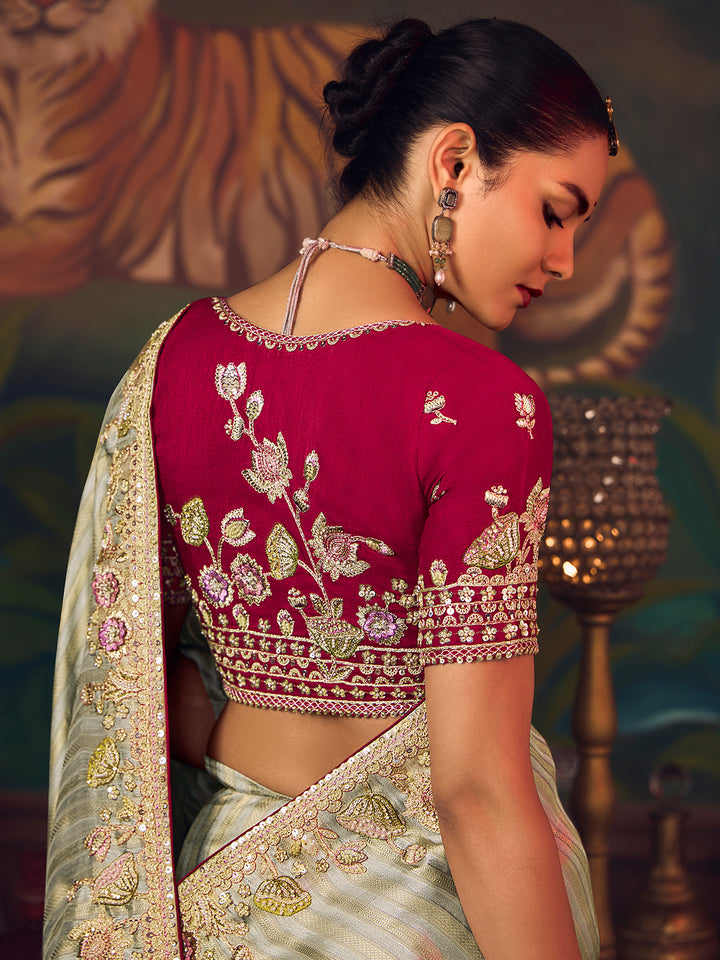 Woman wearing a red embroidered blouse with floral patterns against a decorative background