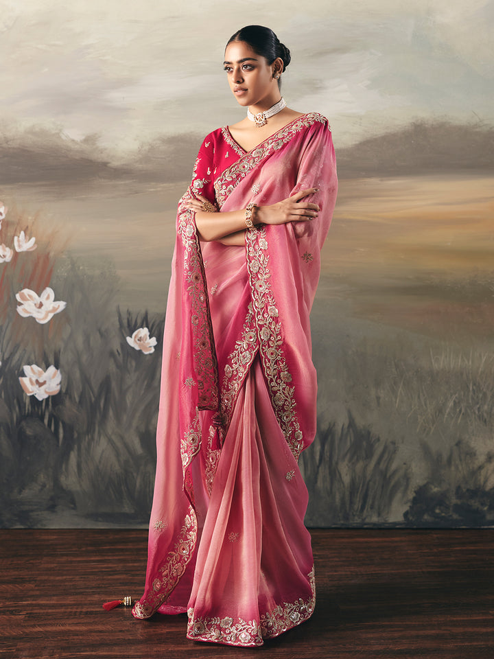 Woman wearing a pink saree with a floral background