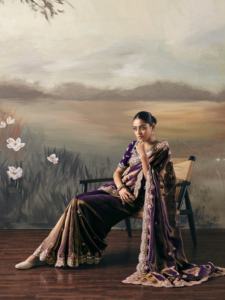 Woman in a traditional saree sitting on a bench with a scenic background