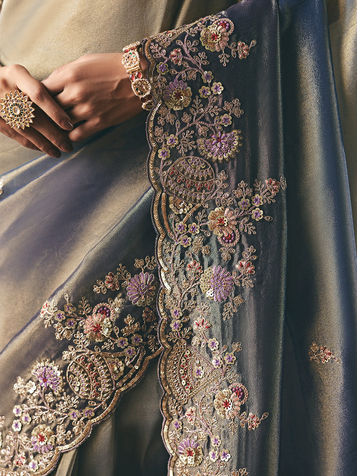 Close-up of a garment with intricate floral embroidery and embellishments.