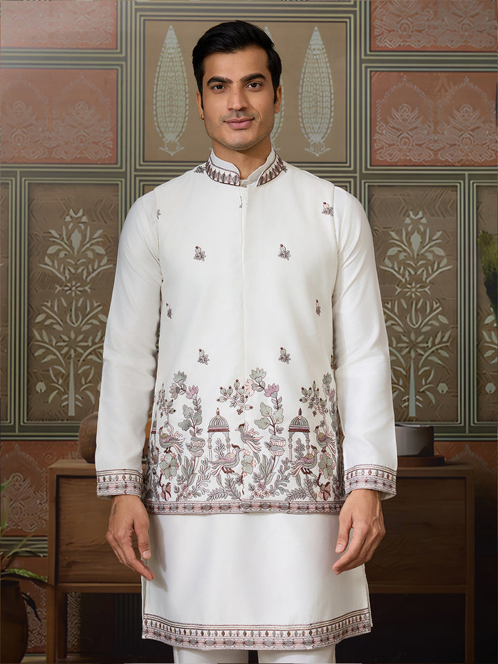 Man wearing a white embroidered kurta with a patterned background