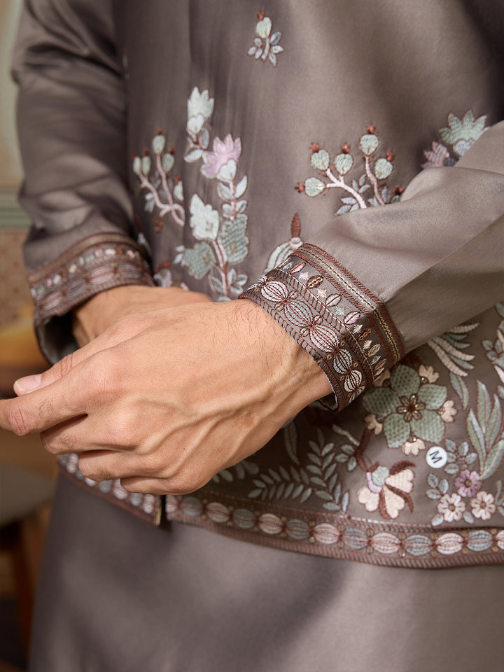 Close-up of a garment with floral embroidery on a neutral background