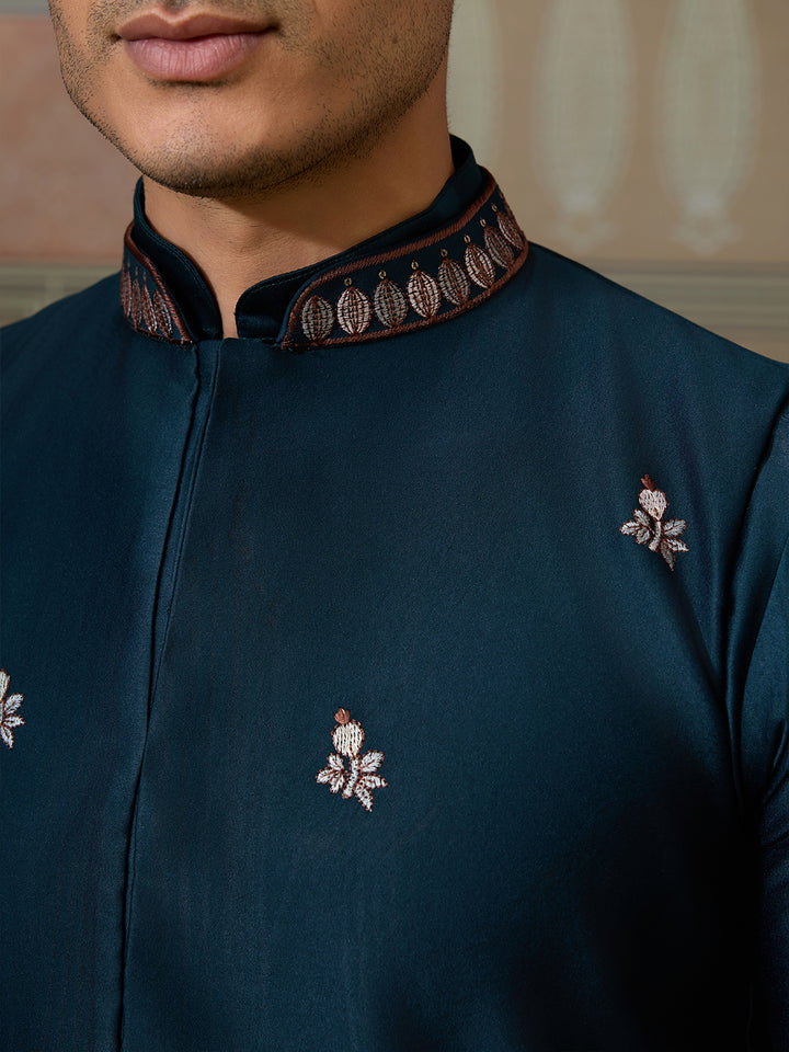 Dark blue traditional outfit with intricate embroidery on a neutral background