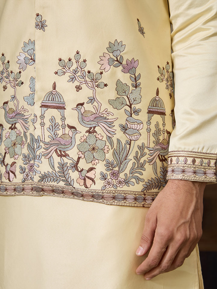 Close-up of a cream-colored garment with intricate floral and bird embroidery.