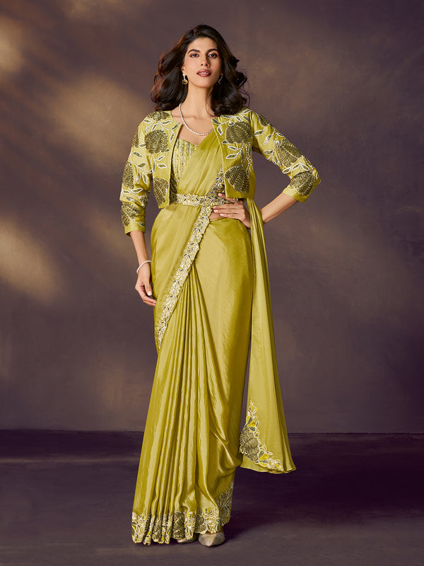 Woman wearing a green saree with a matching jacket against a dark background