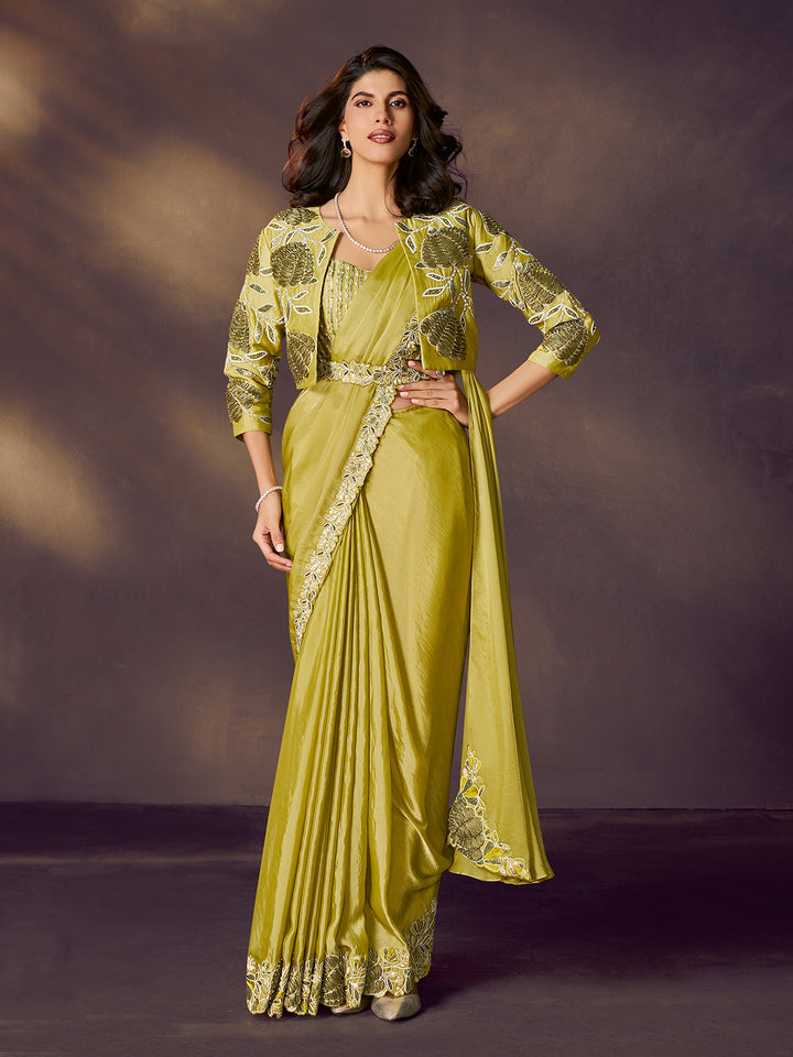Woman wearing a green saree with a matching jacket against a dark background