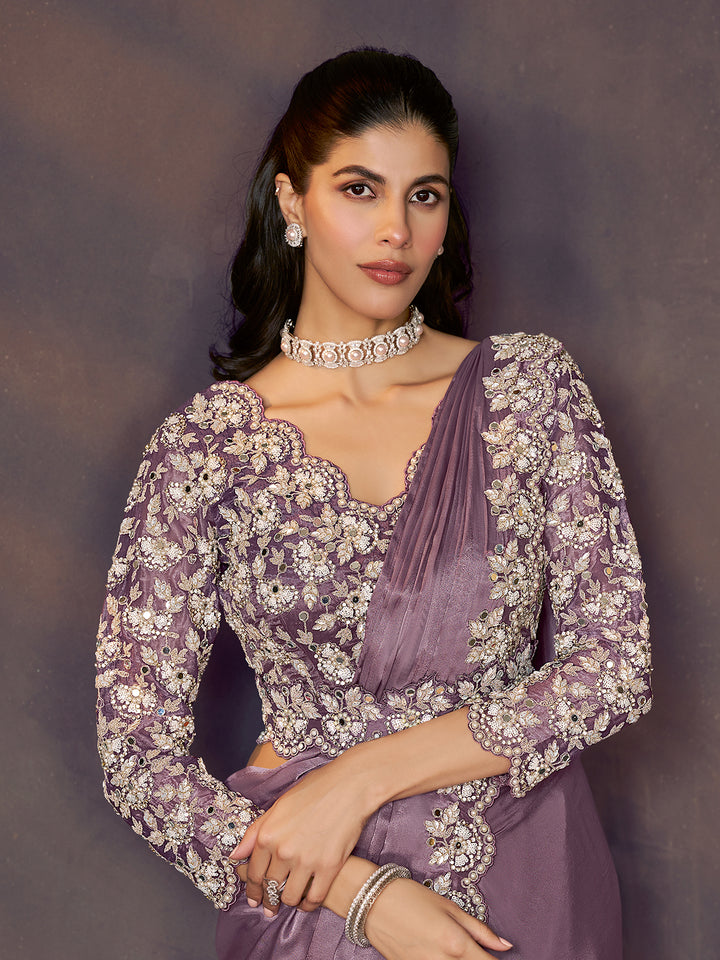 Woman wearing a purple and white embroidered traditional outfit against a dark background