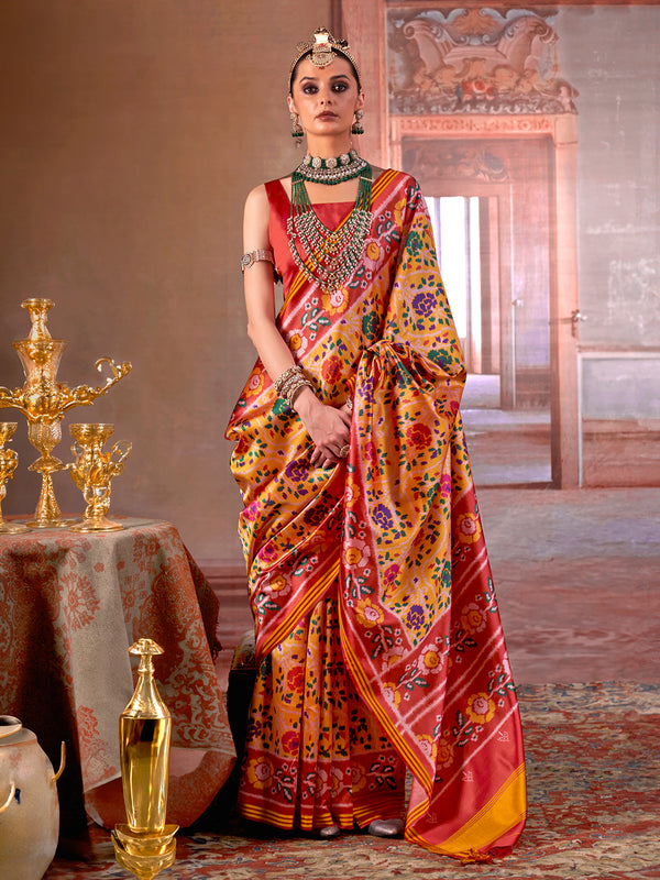 Woman in a colorful saree with intricate patterns in a decorated room.