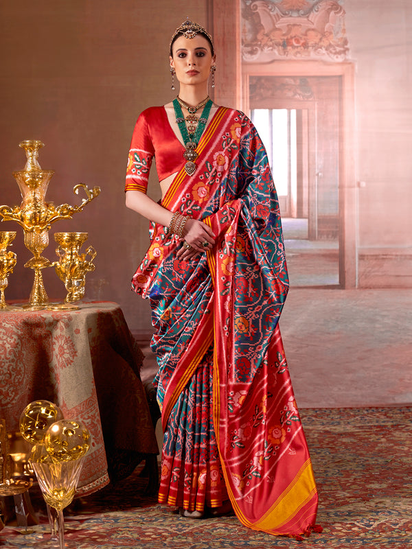 Woman in a colorful saree standing in an ornate room with gold decor.
