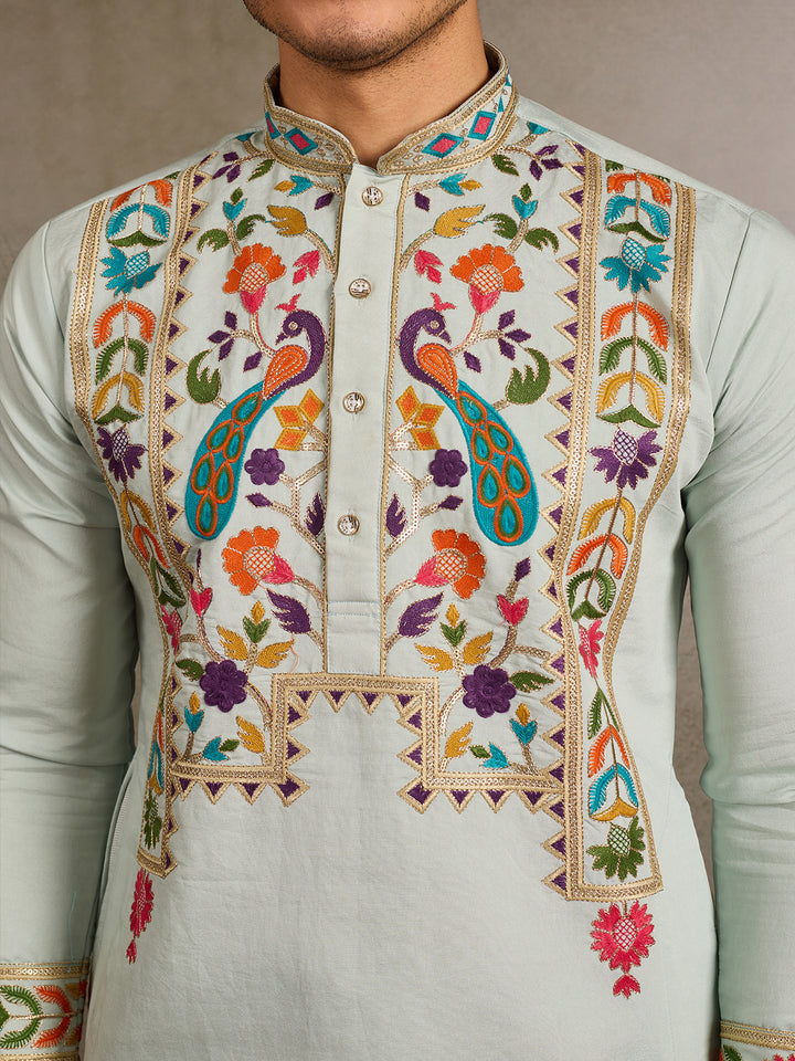 Traditional embroidered kurta with colorful patterns on a plain background