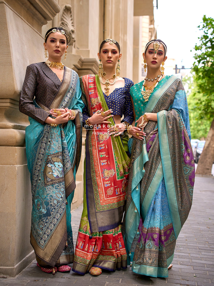 Three women in traditional sarees standing together outdoors.