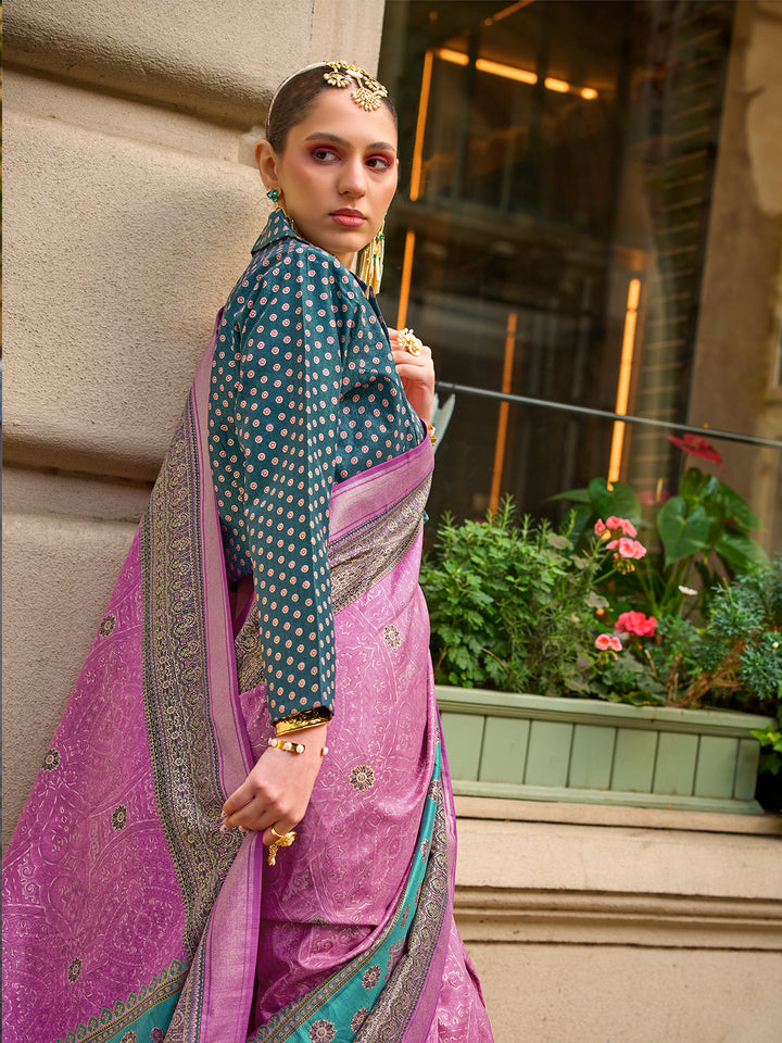 Woman in a traditional outfit with a pink and blue saree standing against a building.