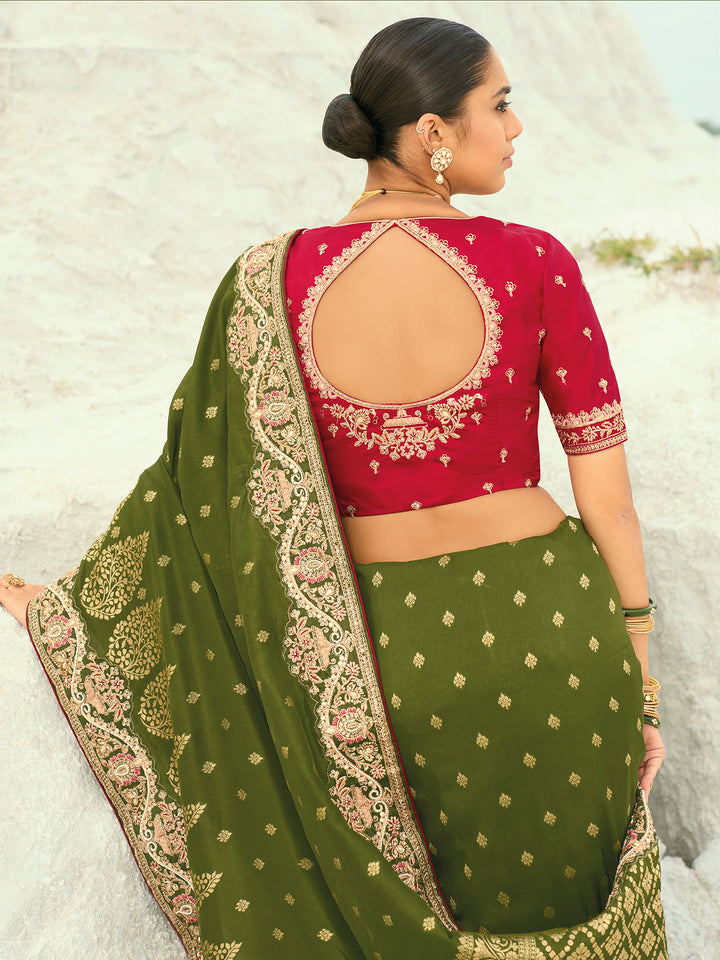 Woman wearing a red blouse with a green saree in a natural setting