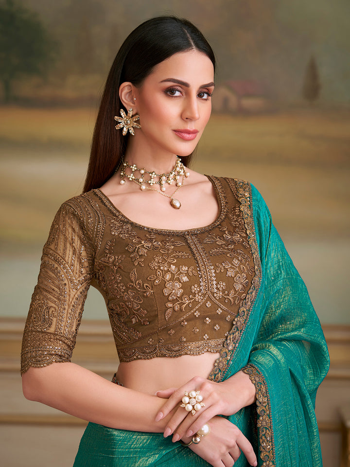 Woman wearing a traditional outfit with gold blouse and green dupatta against a blurred natural background