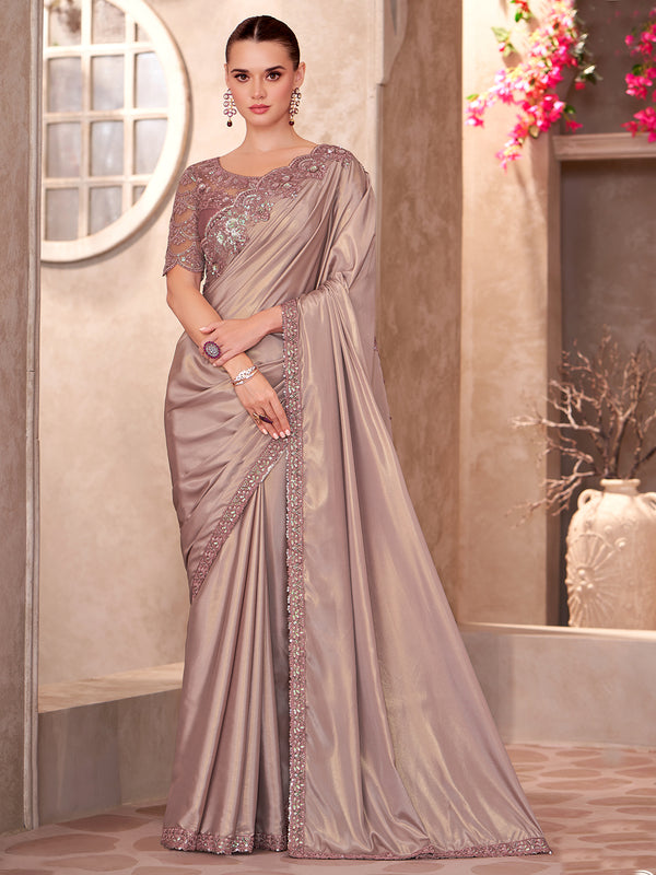Woman wearing a gray saree with intricate designs indoors.