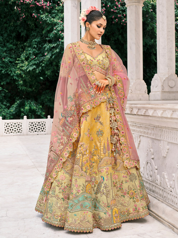 Woman in a traditional embroidered yellow and pink saree with floral decorations, standing outdoors.