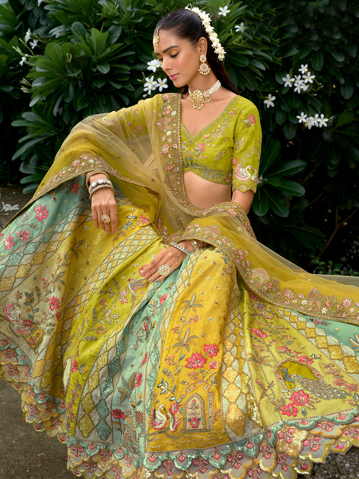 Woman in a traditional embroidered yellow and green outfit with floral patterns, sitting outdoors.