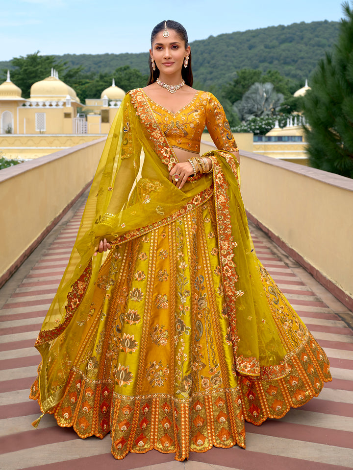 Woman in a yellow and orange traditional outfit standing on a balcony with greenery in the background