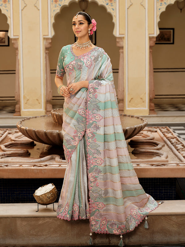 Woman in a traditional saree standing in an ornate indoor setting