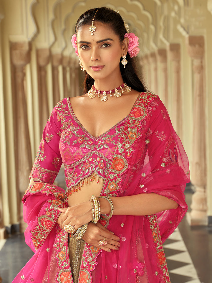 Woman in a traditional pink embroidered outfit with jewelry in an ornate setting
