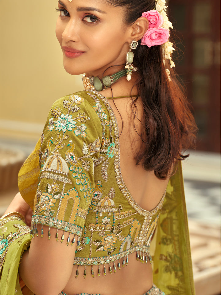Woman wearing a green embroidered traditional outfit with floral hair accessories.