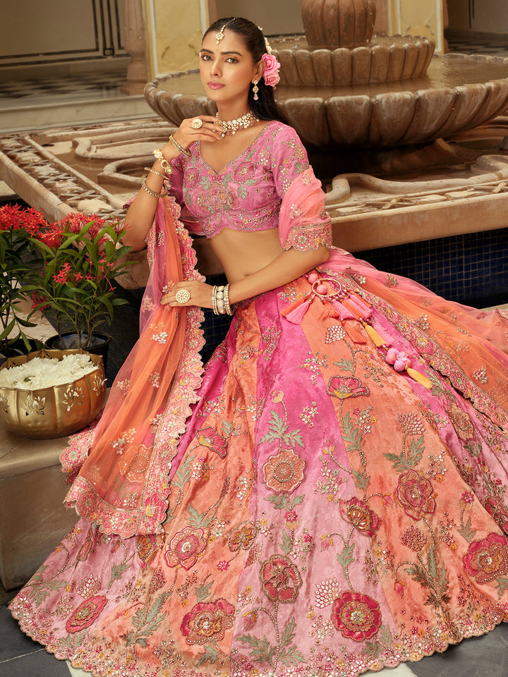Woman in a traditional pink and orange embroidered outfit with a fountain in the background