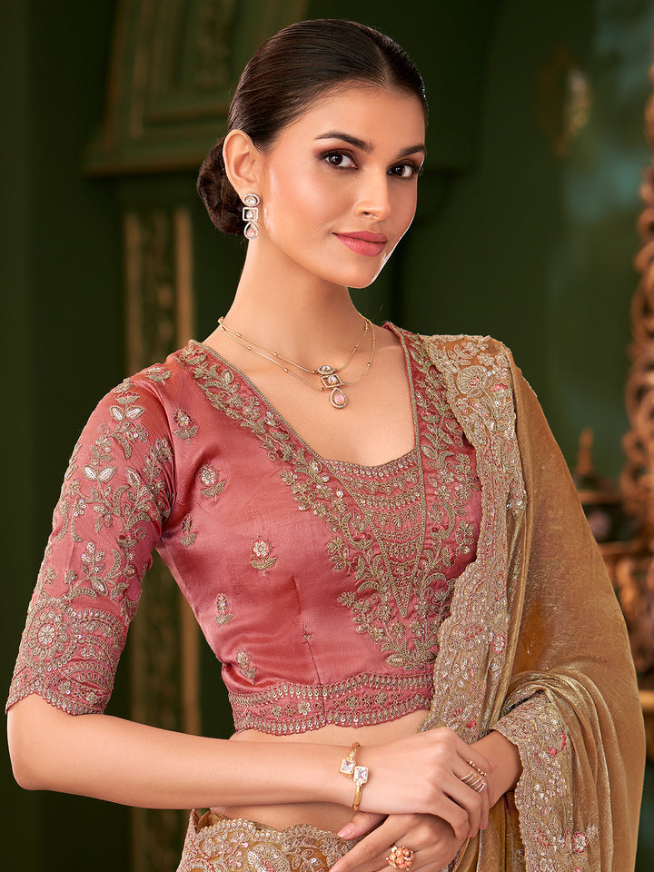Woman wearing a traditional pink blouse with gold embroidery and a matching dupatta against a green background