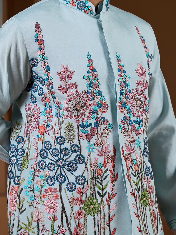Light blue shirt with colorful floral embroidery on a wooden background