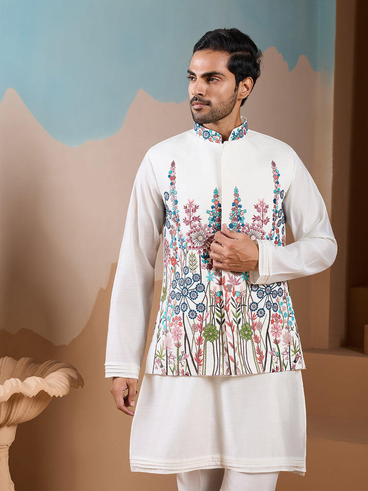 Man wearing a traditional embroidered kurta with a decorative background