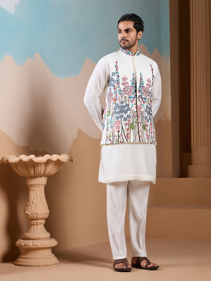 Man wearing a traditional outfit with a floral vest in a decorative setting