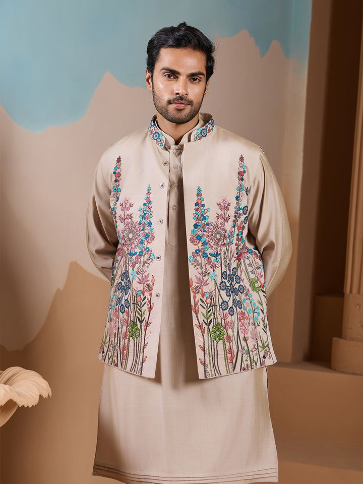 Man wearing a traditional outfit with floral embroidery in a decorative setting