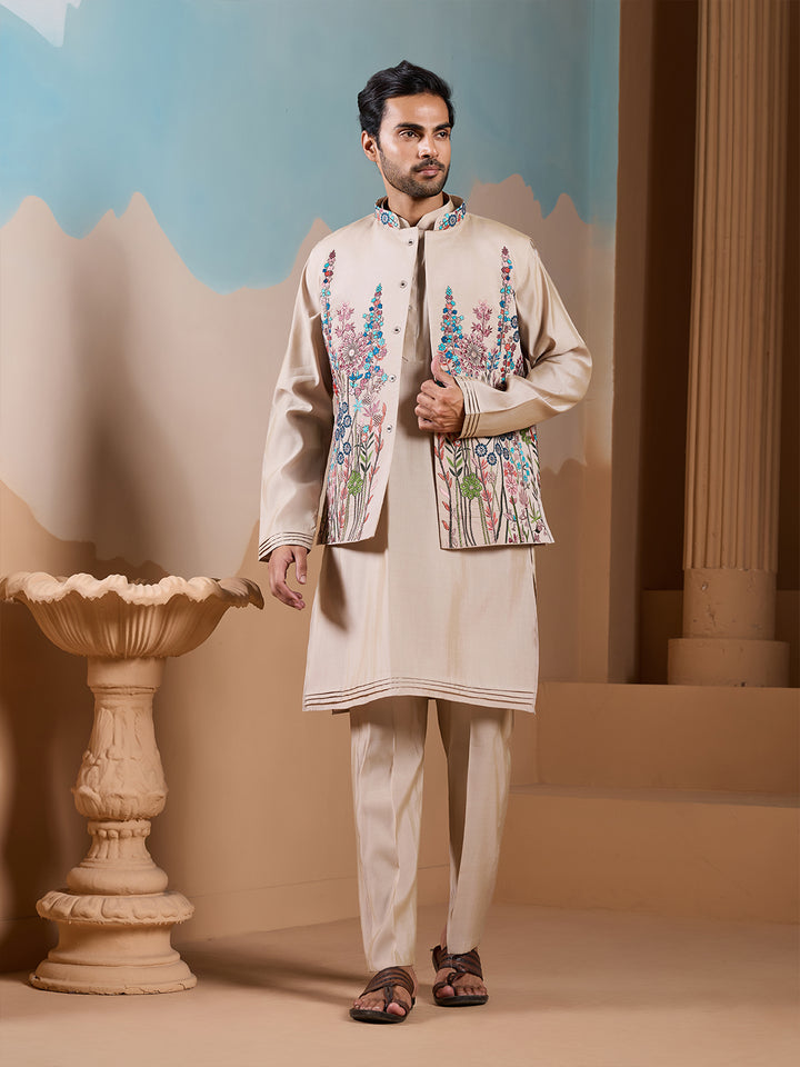Man wearing a traditional outfit with floral embroidery in a decorative setting