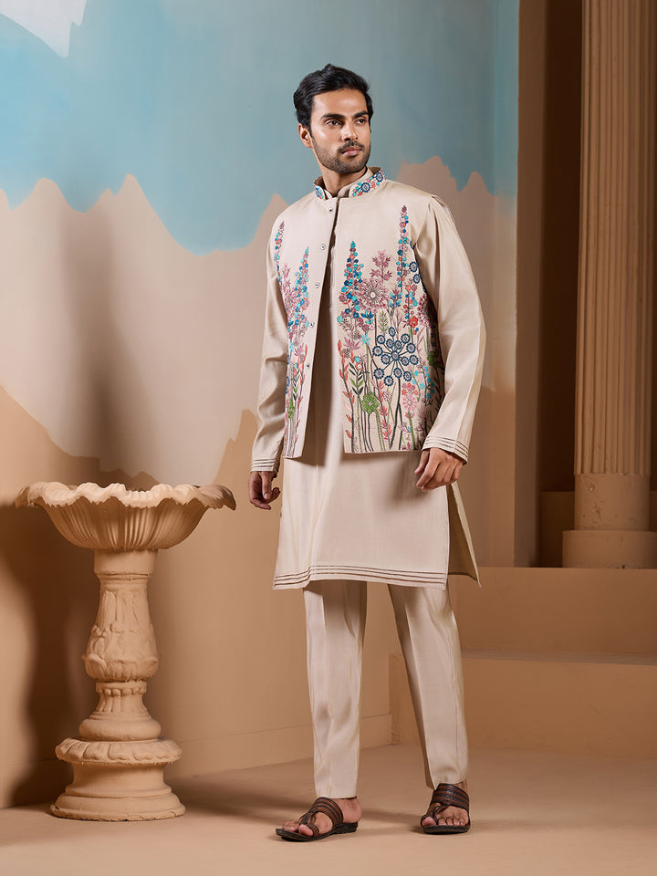 Man wearing a traditional embroidered outfit in a decorative setting