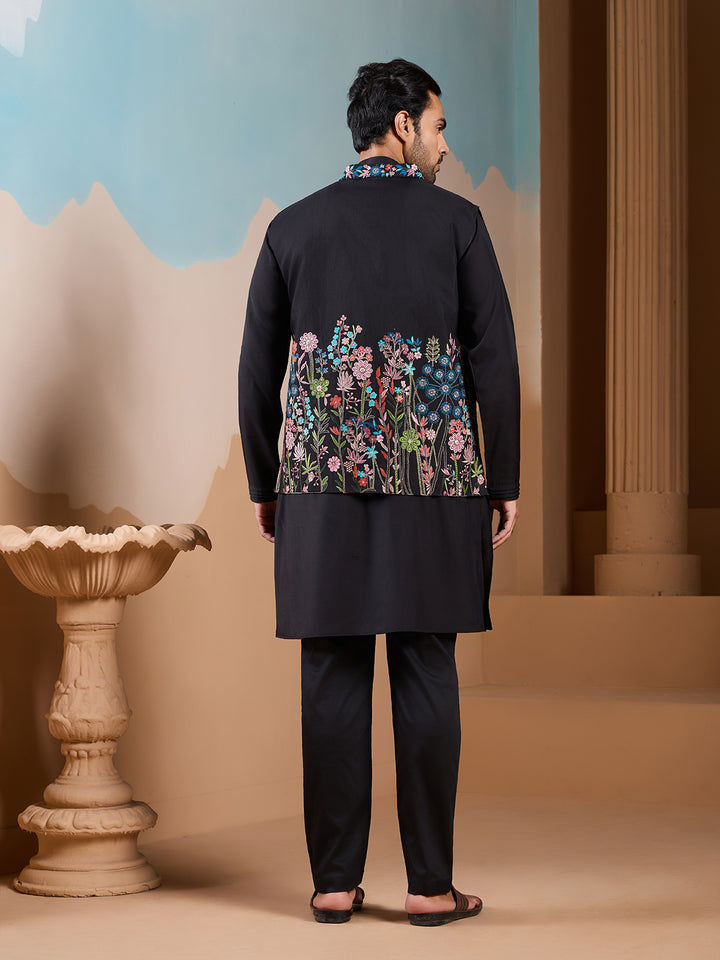 Man wearing a black kurta with floral embroidery in an outdoor setting