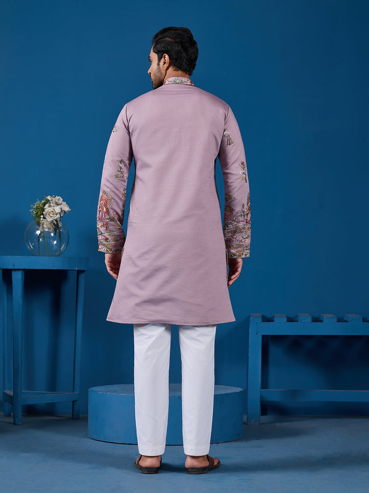 Man wearing a mauve kurta with white pants against a blue background